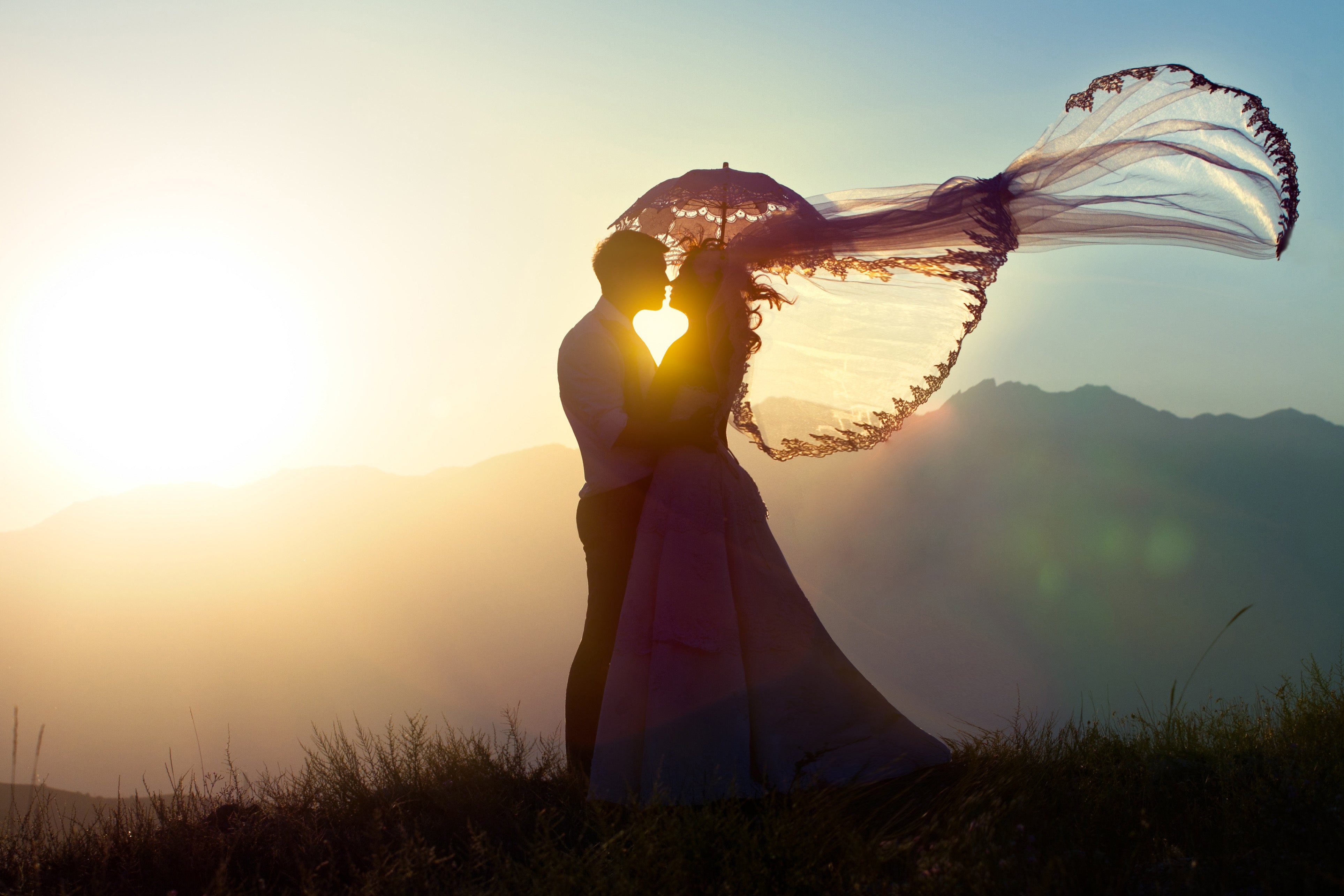 Bride and groom about to kiss in the sunset with creative lighting