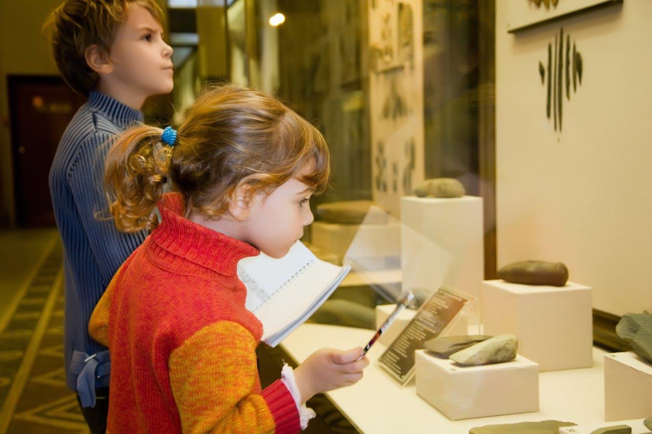 Young kids looking at a display in a museum