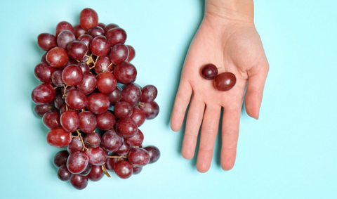 Vitamin C Source: Grapes image with hands