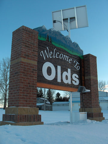 Olds, Alberta city welcome sign lit by Watt-a-Light.  This is a daytime photo of signage.