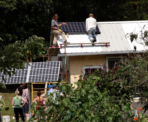 Two people on roof installing solar panels