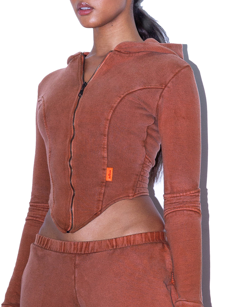  Model wears SIZE X-SMALL TONIK Corset Hoodie in Spiced Ginger by TheKLabel