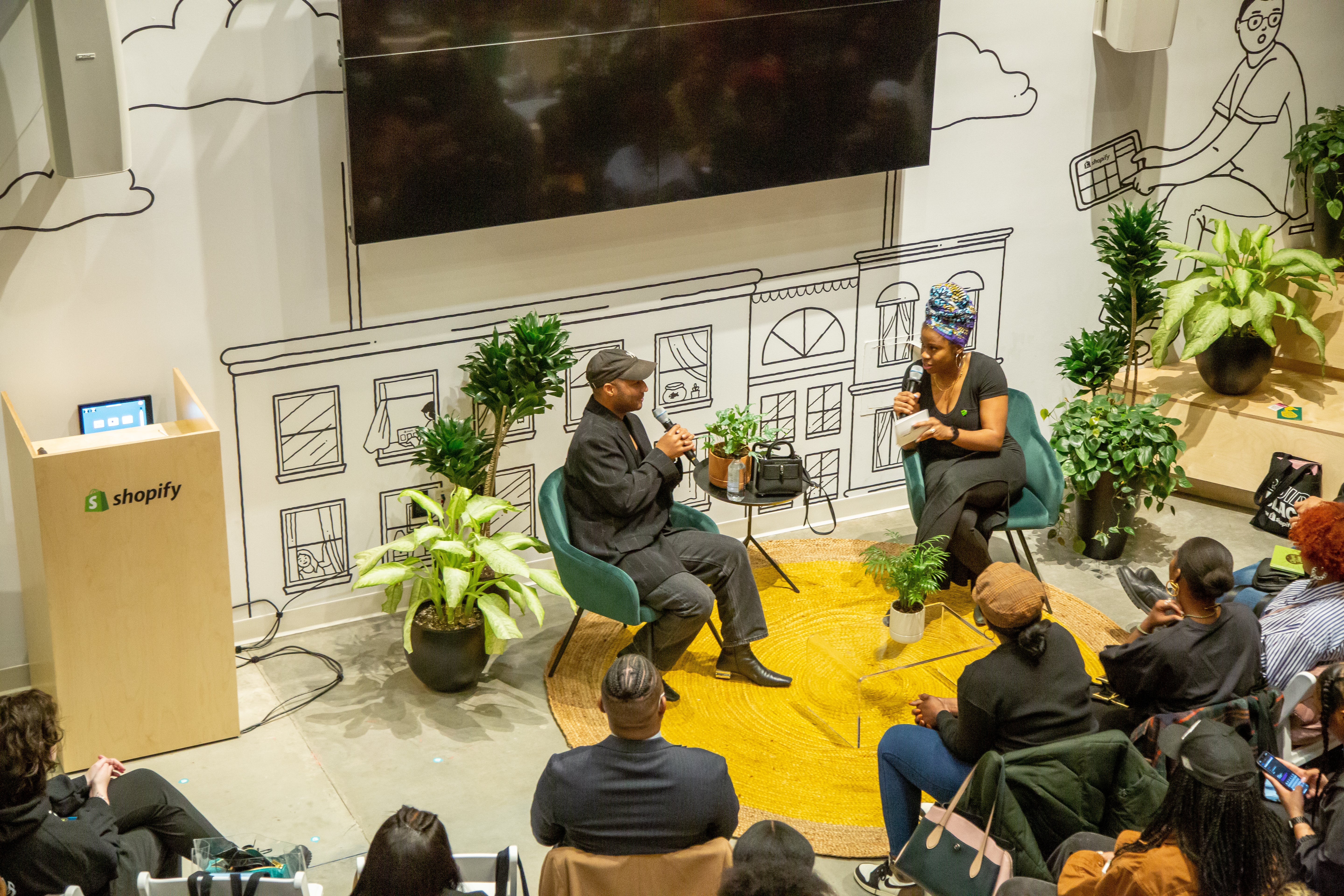 A photo of an on-stage conversation with Brandon Blackwood, a successful Black entrepreneur, in front of an audience from the Build Black Community.