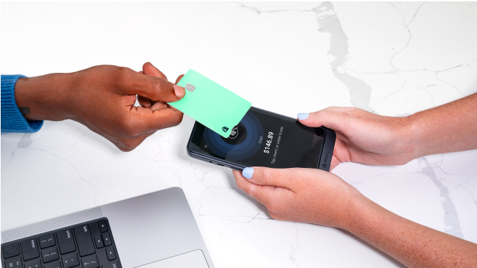 A Black merchant using the Shopify Credit business card to make a purchase in-store