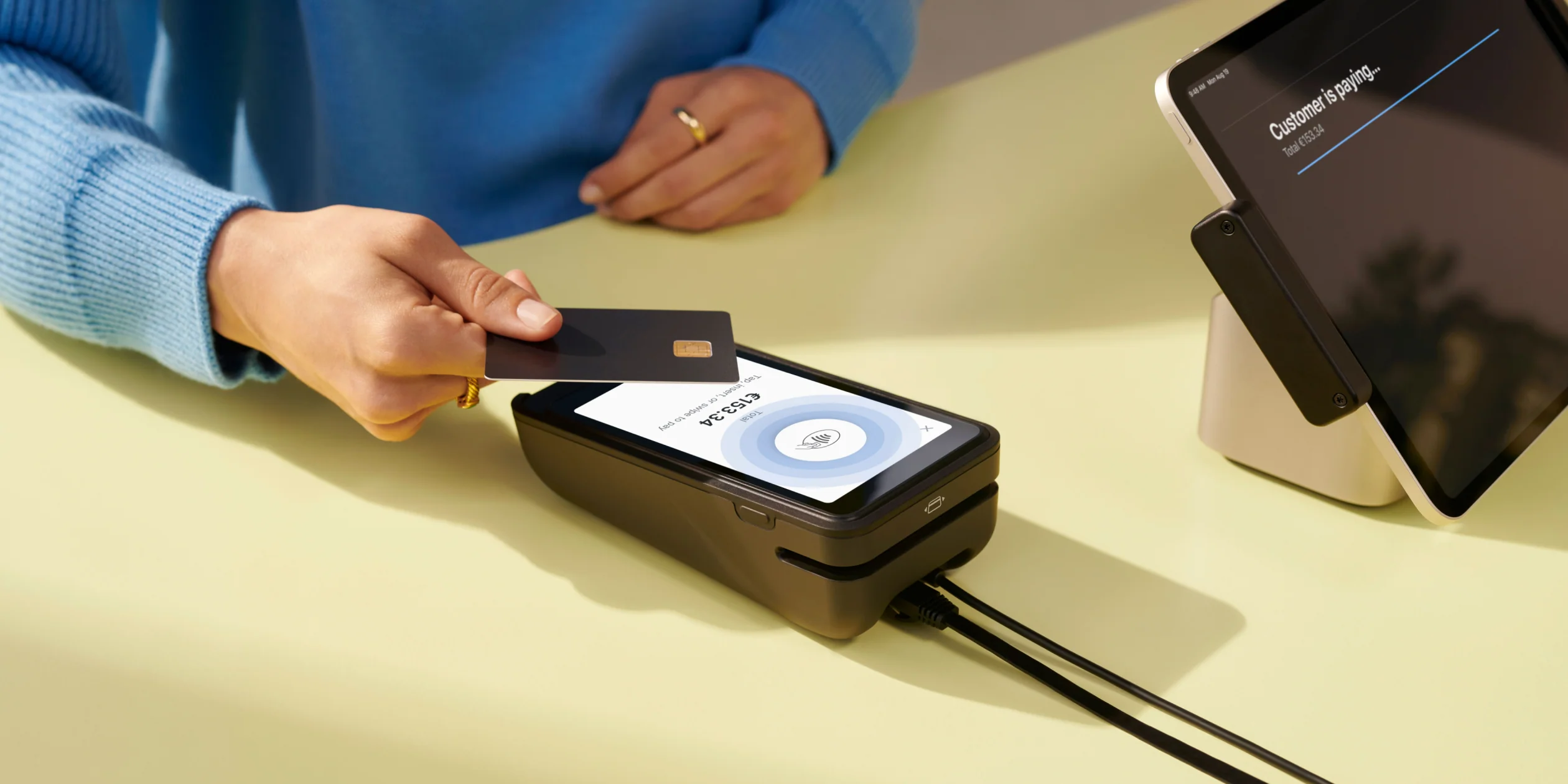 A customer taps their card on POS Terminal at the counter.