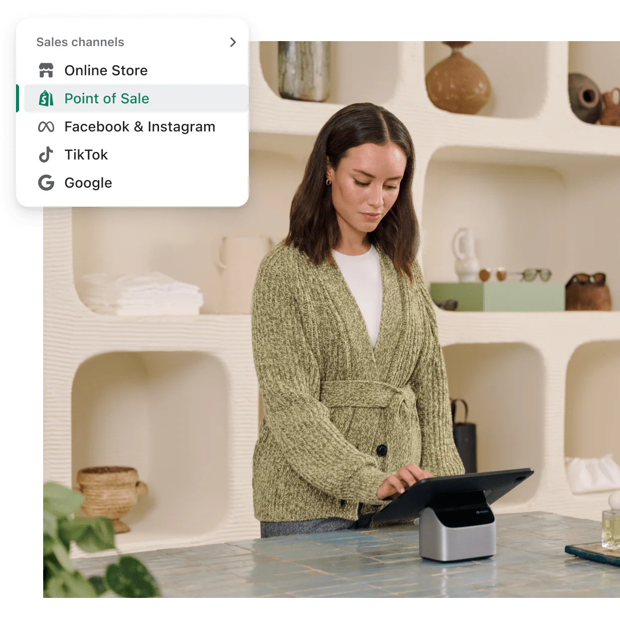 A sales associate stands behind a retail counter using a POS tablet.