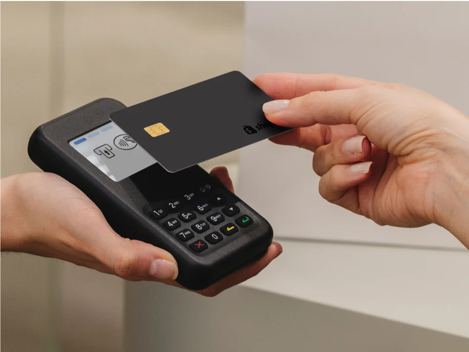 Customer tapping their card on the Tap & Chip Card Reader on a sales counter.