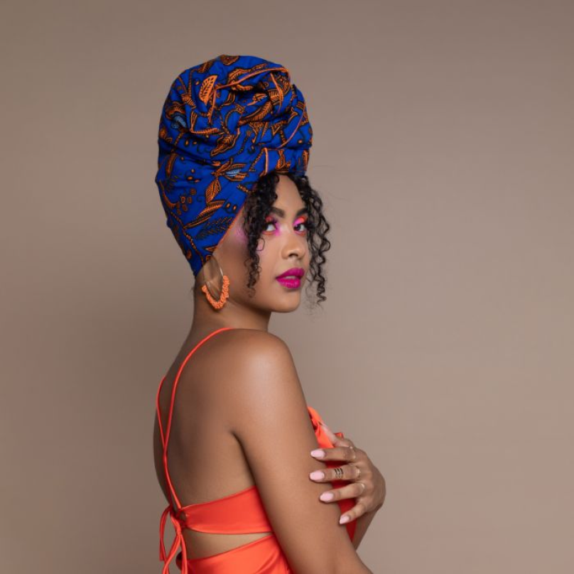 Uchenna Ngwudo, CEO de Cee Cee’s Closet, vistiendo colores vivos y un pañuelo azul en la cabeza