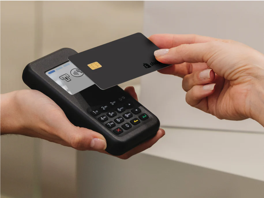 A customer taps their payment card on a Shopify POS card reader.