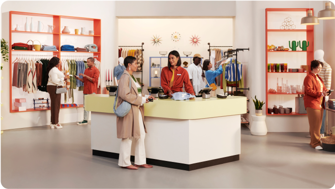 Inside a busy retail store, staff are serving customers at the checkout and on the floor with Shopify POS hardware.