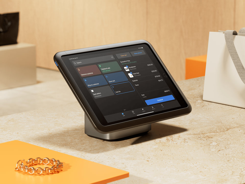 A tablet running Shopify POS sits on a retail counter.