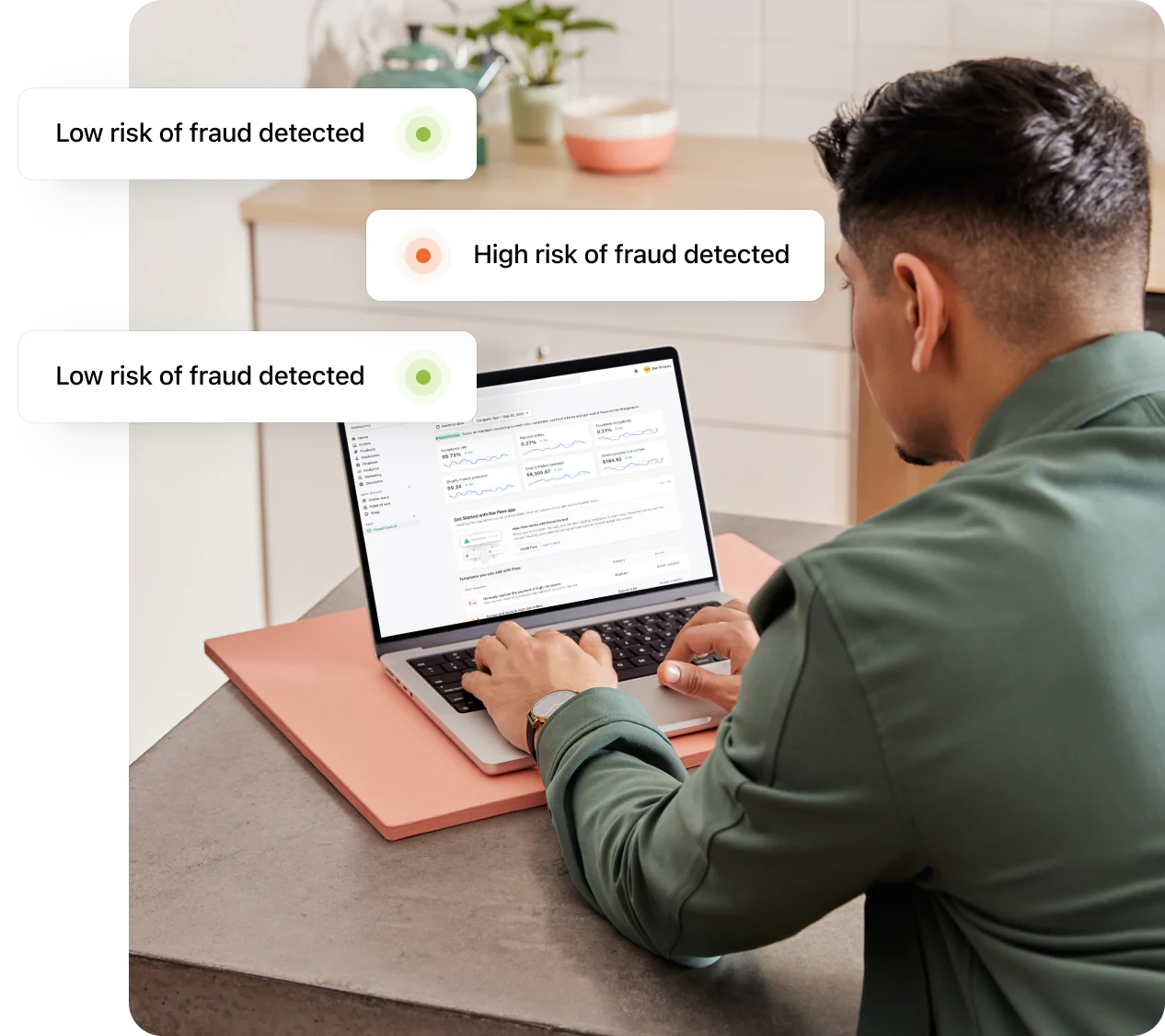 Shopify merchant sitting at a desk with a laptop and receiving notifications of low-risk and high-risk fraud.