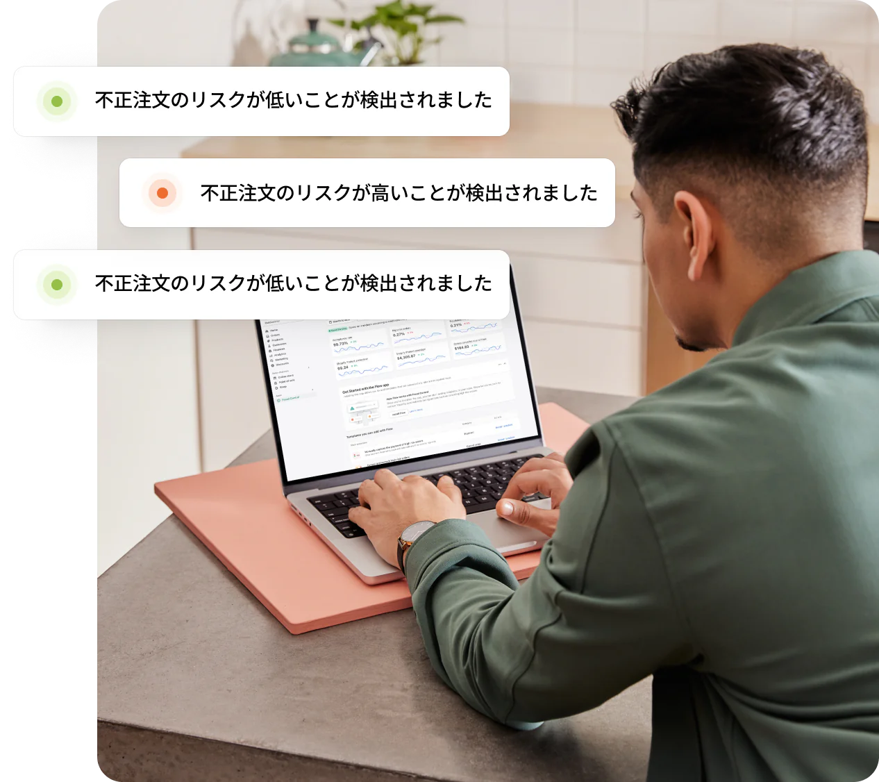 デスクに座ってノートPCを見ているShopifyのマーチャントが、低リスクと高リスクの不正注文の通知を受け取っている。
