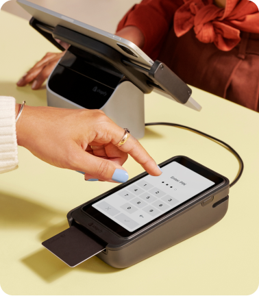 A closeup of a customer entering their PIN on Shopify POS Terminal at the counter.