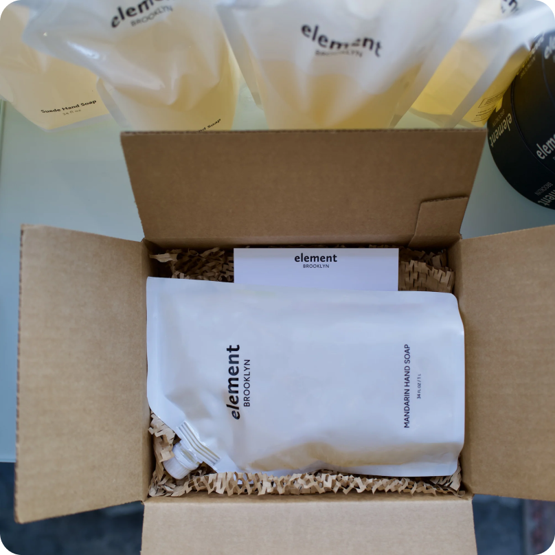 A soap refill from Element Brooklyn inside an open box with additional refill packages nearby for shipping