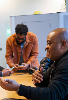 A photo of a Black entrepreneur during a workshop with a Black merchant success manager, discussing entrepreneurial tips.