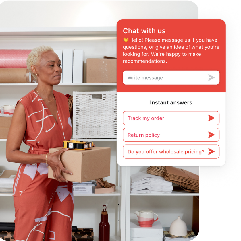 Business owner is standing in her back office carrying a box while doing inventory. Three instant answers are showing on screen, this feature of Shopify Inbox helps customers help themselves without the need for live chat.