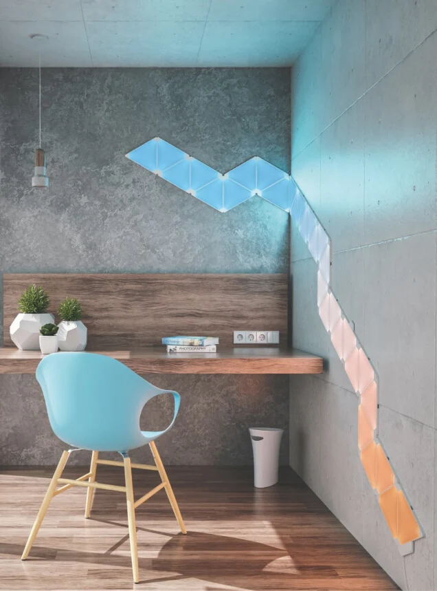 Panneaux lumineux Nanoleaf de forme triangulaire formant une frise décorative le long du mur d’un bureau