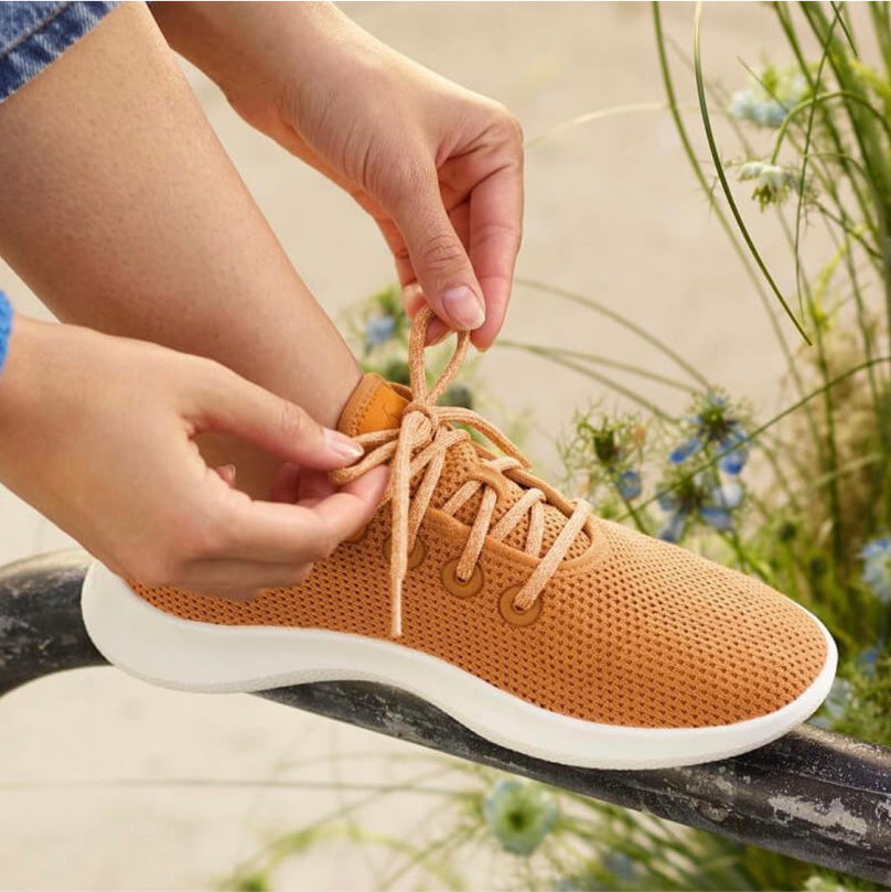 Image of a person tying an Allbirds shoe