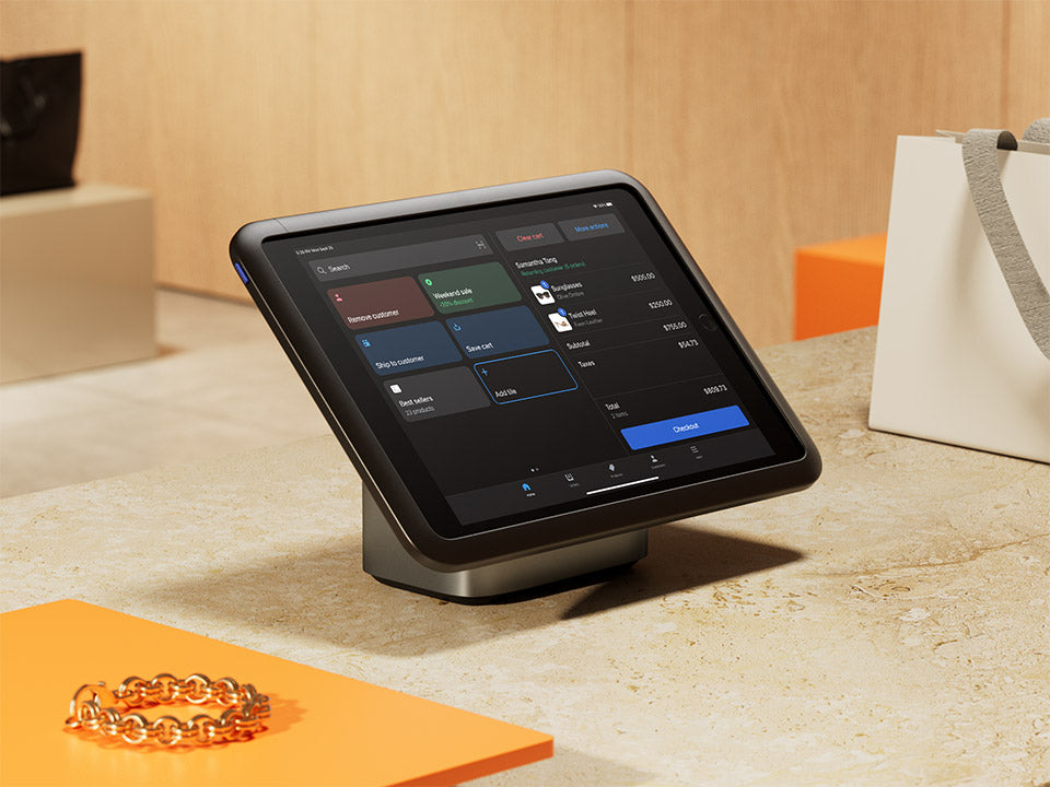 A POS tablet is displayed on a countertop with a Shopify POS screen.