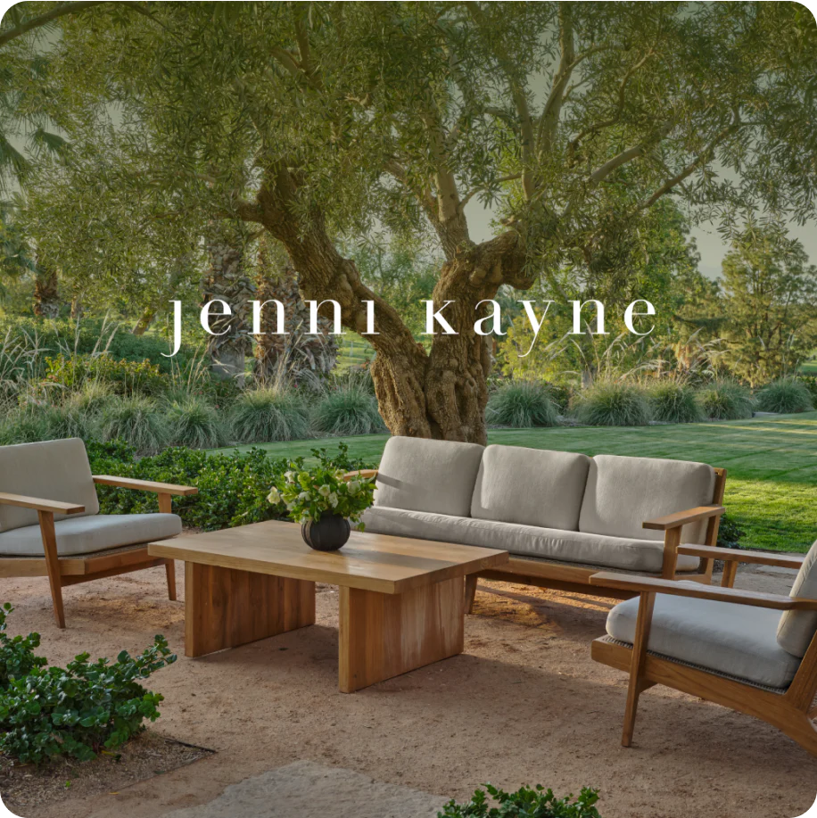 An outdoor furniture set in a beautiful backyard. Over the image is Jenni Kayne's logo.