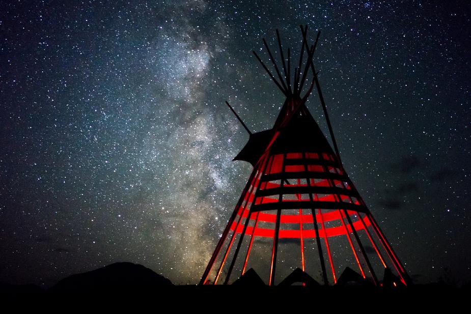 Red teepee with starry sky behind