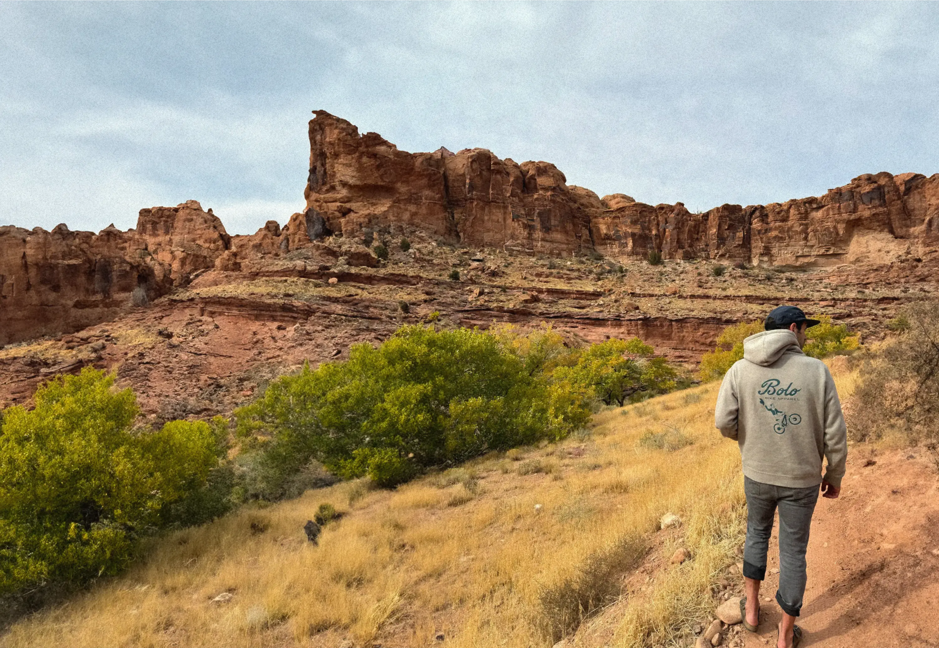 Man in bolo bike sweatshirt looking at desert landscape