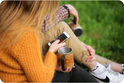 a girl sitting on the grass is using her cellphone