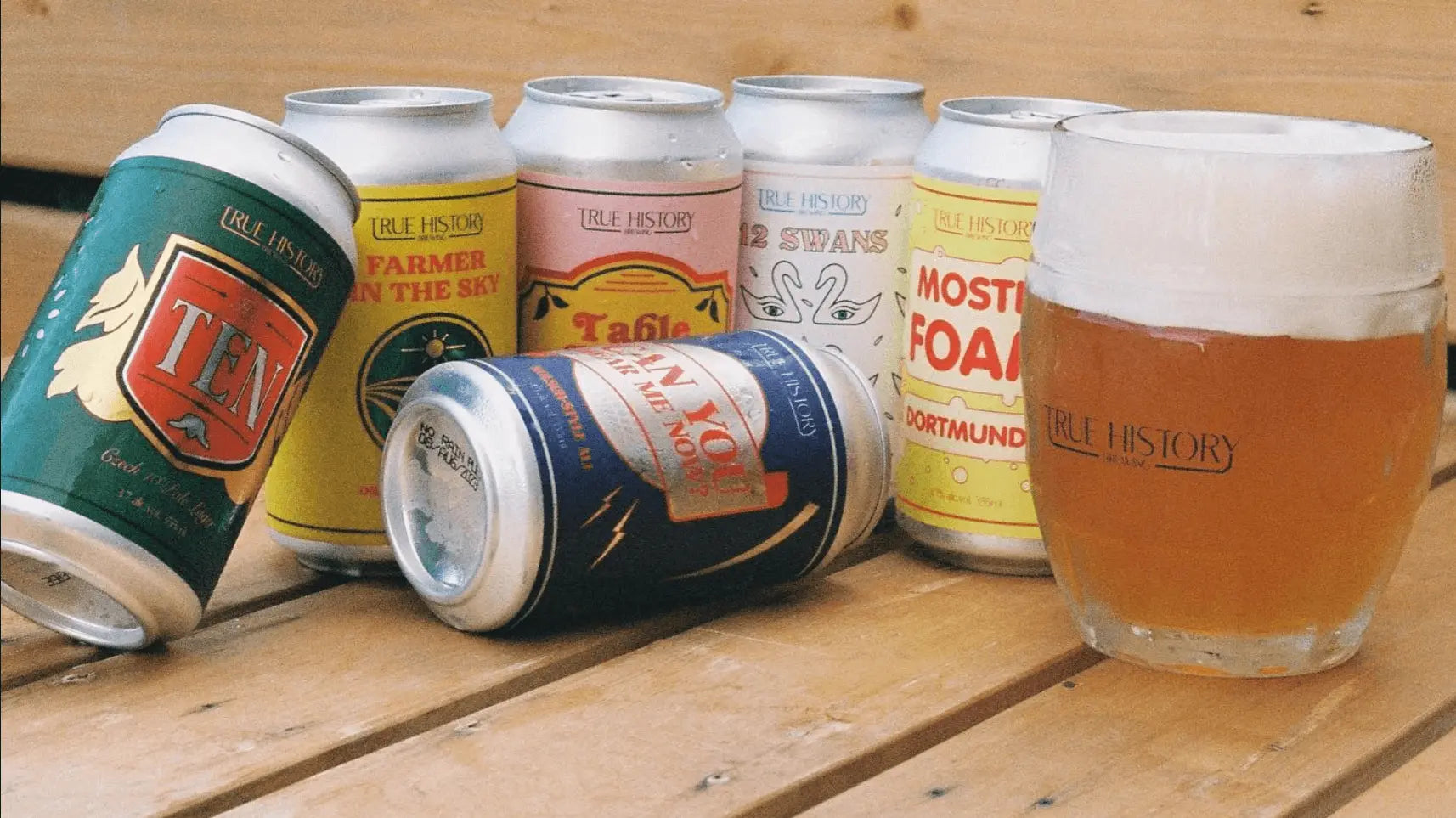 Film photo of a selection of THB beer cans on a wooden ledge