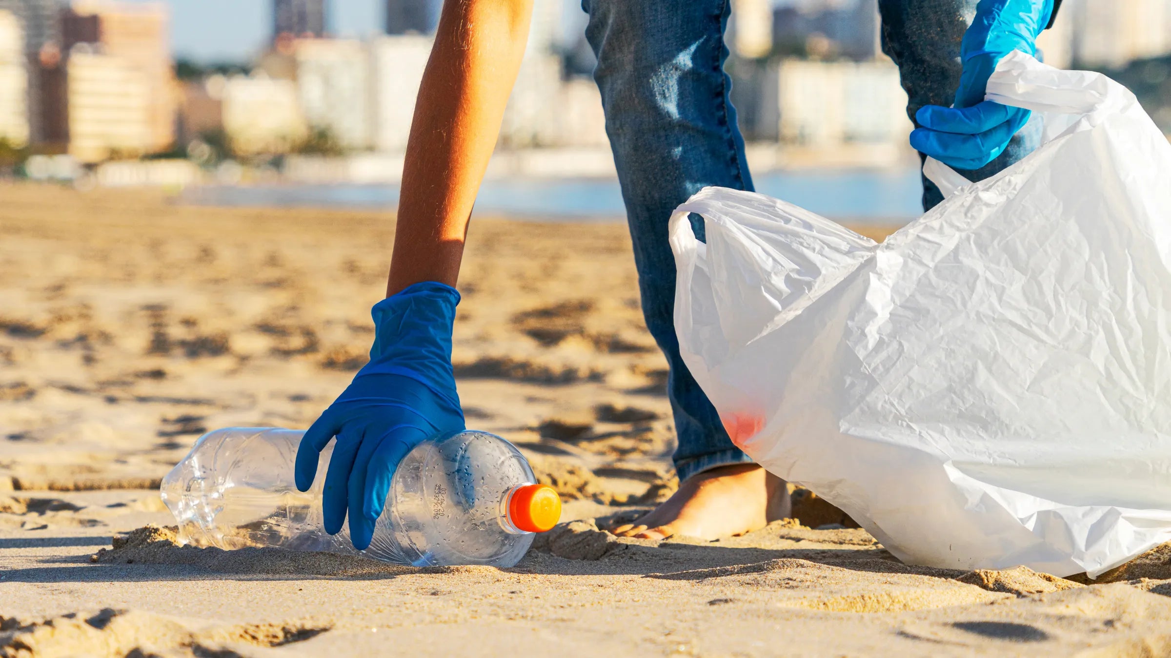 Picking up a plastic bottle on the beach