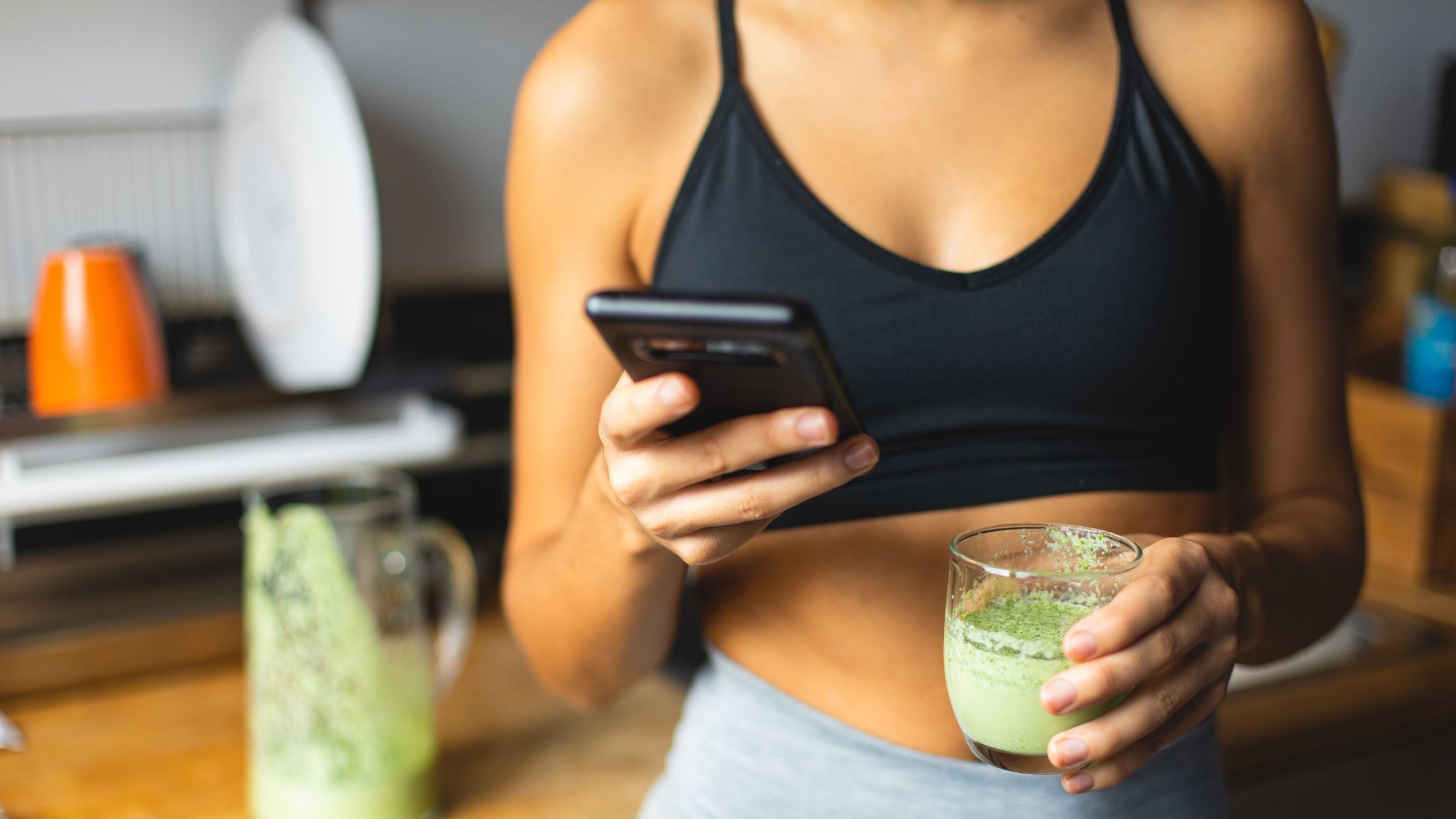 A young woman learning more about detoxing using superfoods while enjoying a green smoothie.