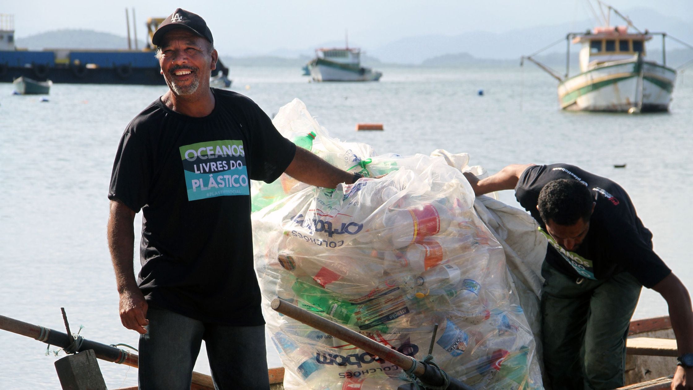 Plastic Bank workers colleting plastic from a bay in the Pacific ocean.