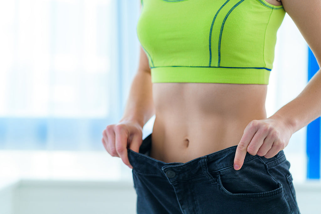 how long does it take to get into shape: Slim woman holding her large jeans