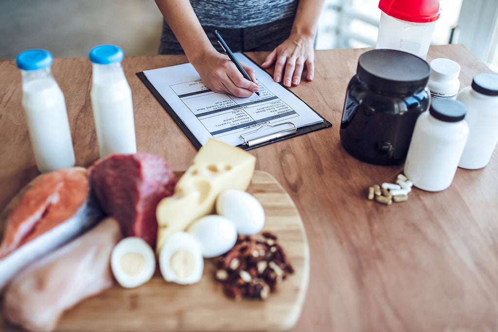 how much protein do you really need: woman writing with sports nutrition