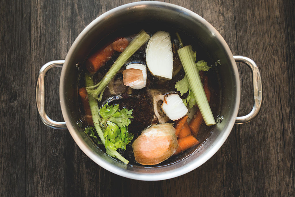 Bone broth for weight loss: Variety of vegetables and animal bones in a pot