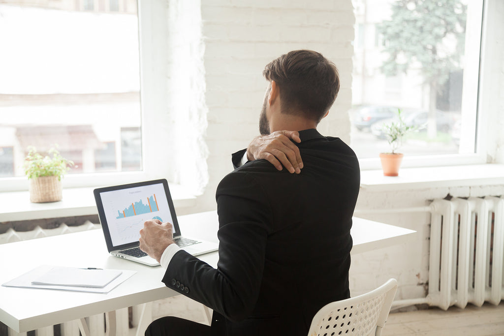 Man does shoulder mobility exercises at desk