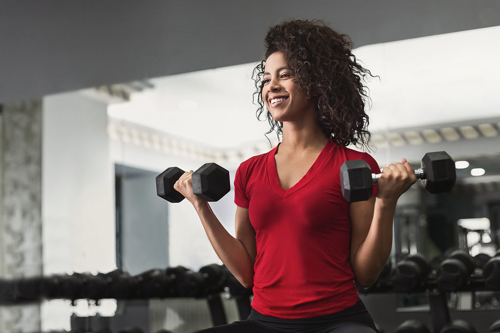 Concentric vs Eccentric: Woman doing biceps workouts in gym