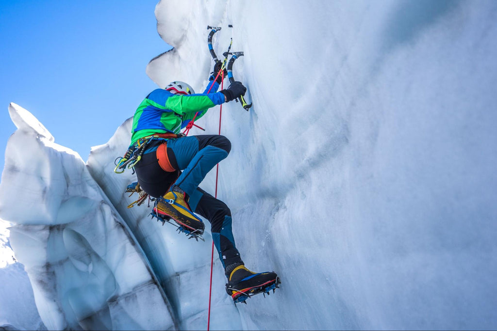 ice climbing: person reaching the top of the Alps