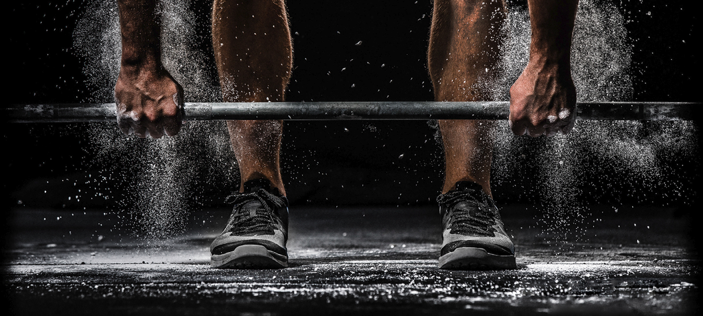 Types of deadlifts: Man lifting a barbell