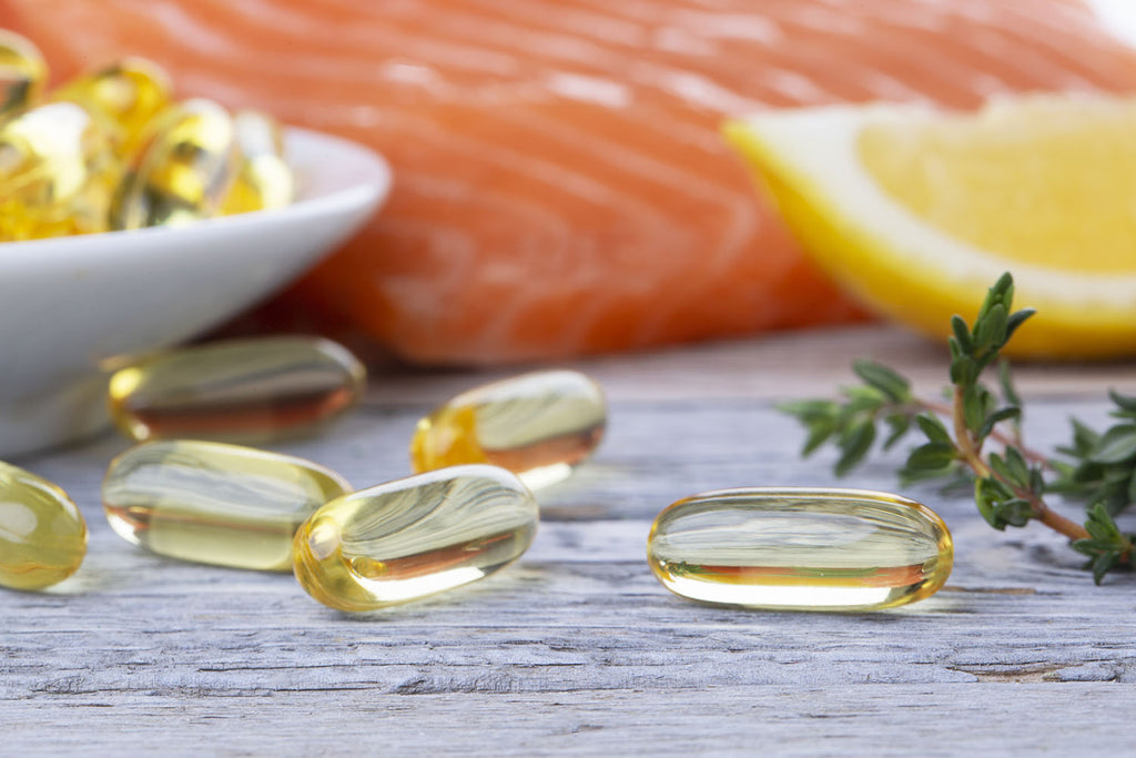 omega 3 6 9: tablets of omega-3 with a sliced lemon and salmon in the background