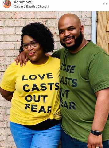 Love Casts Out Fear, black couple wearing yellow and olive green love casts out fear unisex tshirt