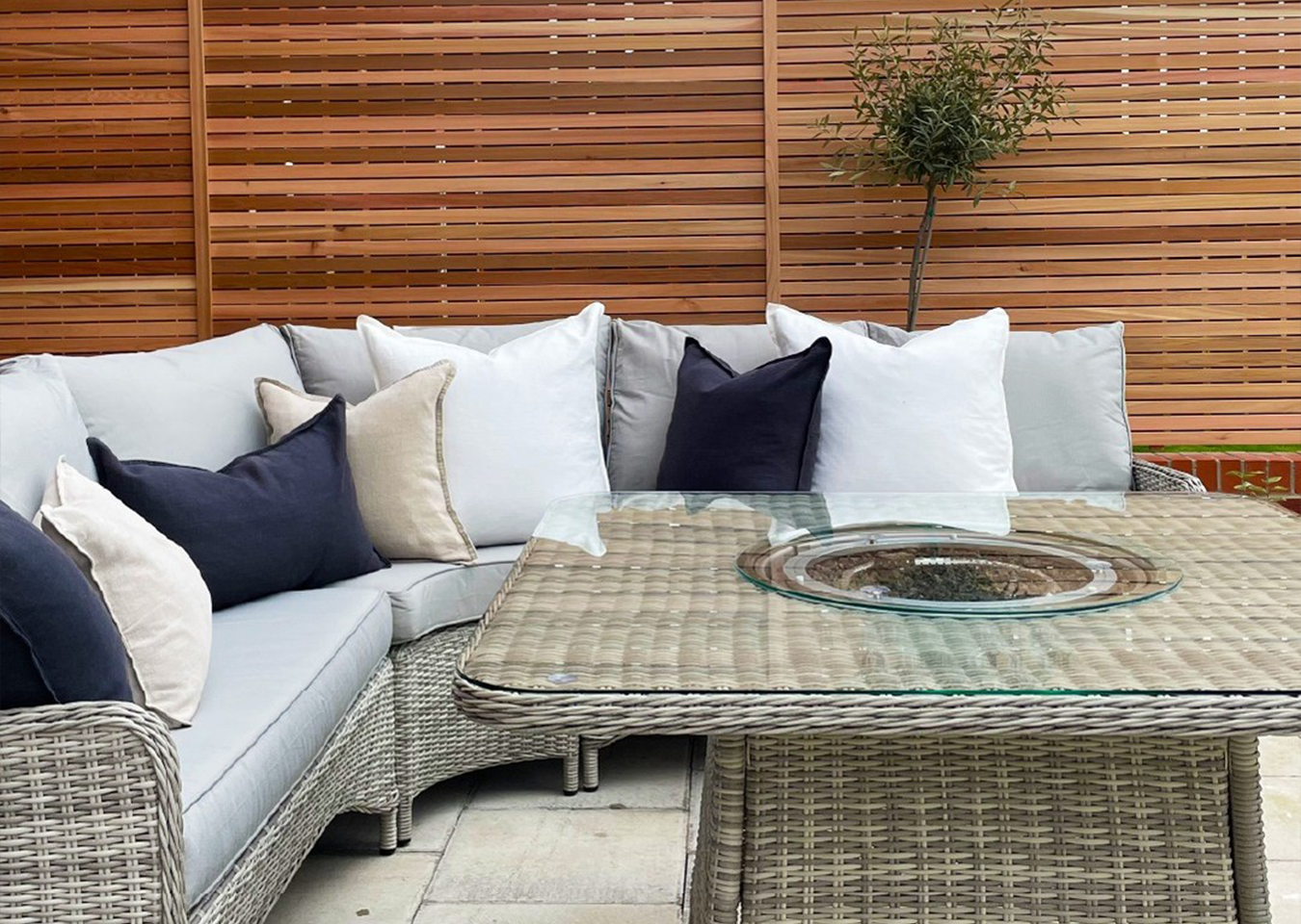Cedar Slatted Panels behind outdoor lounge and seating area. Grey sofas with cushions