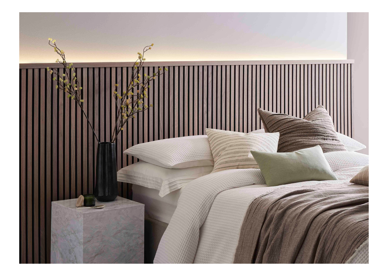 A half-wall headboard design made from SlatWall Midi Walnut panels and a matching Top Trim.