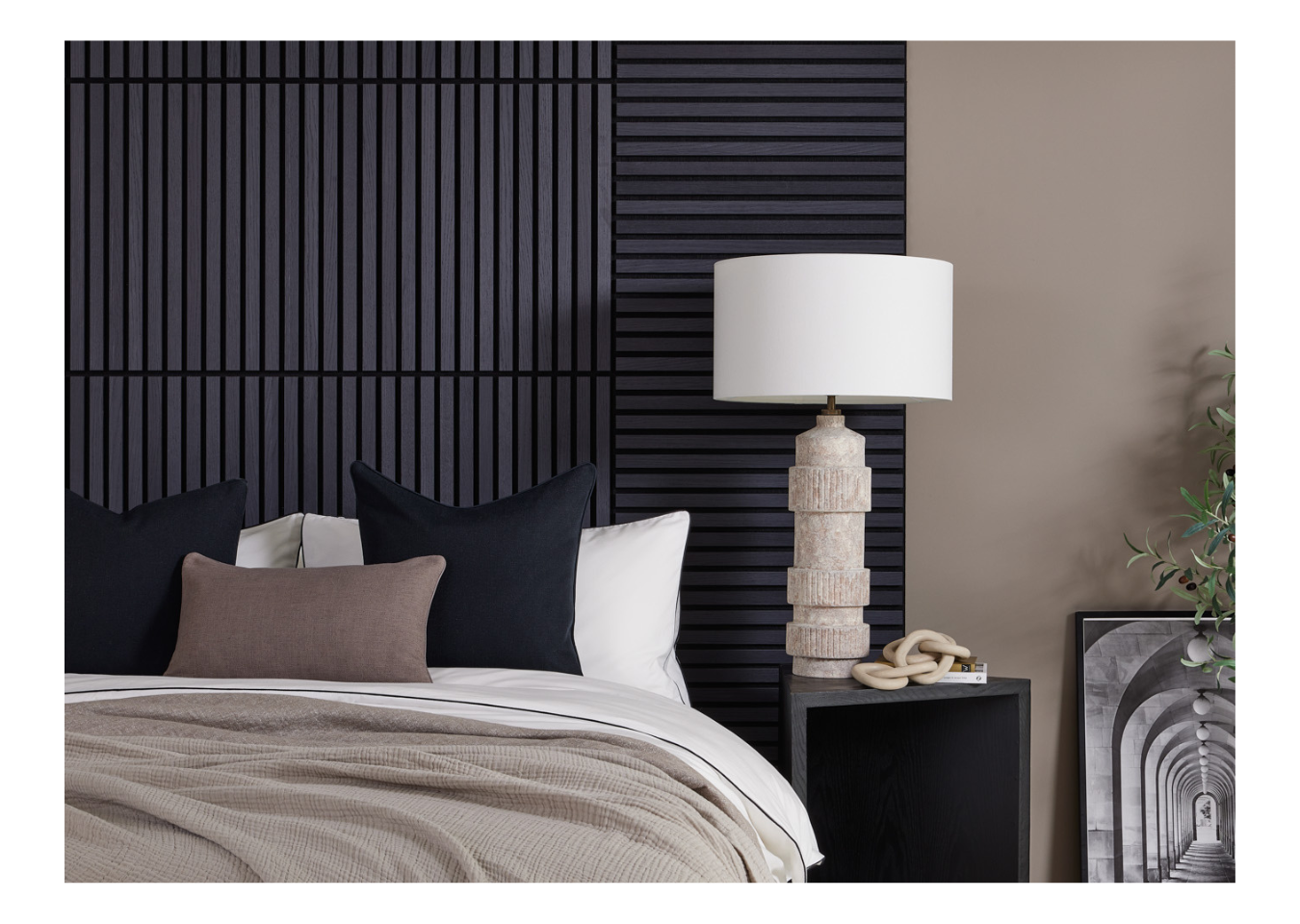 SlatWall Mini Charcoal Black panelled headboard behind a neutral lamp and white bed with black and brown cushions.