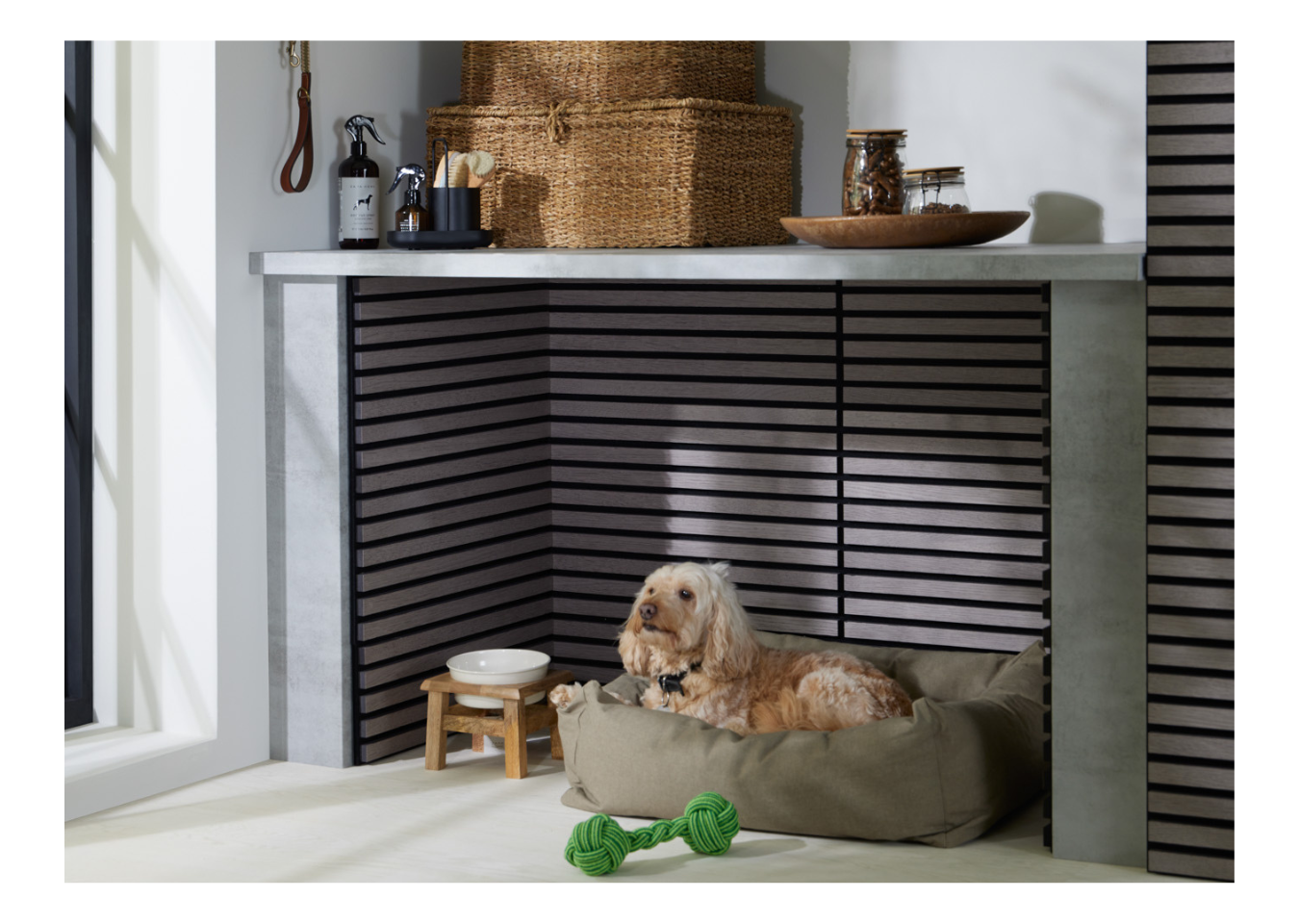 SlatWall Mini Grey Oak panels in a utility room alcove where a beige mixed-breed dog lies in a green bed next to a food bowl.