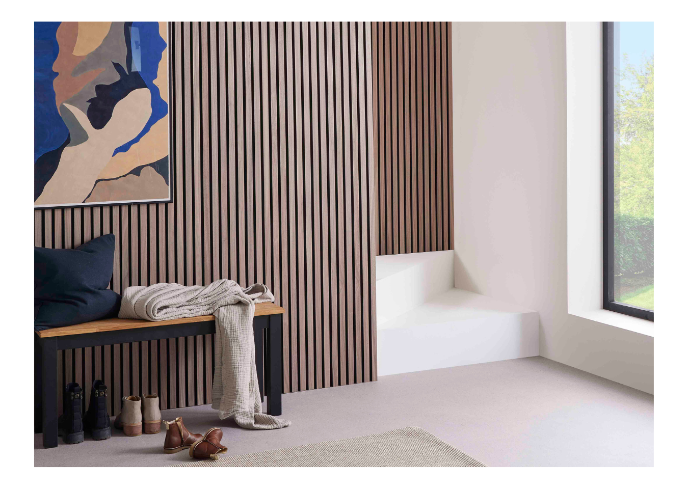 SlatWall Walnut panels in a biophilic design hallway featuring blue and beige wall art and a cushion and blanket on a bench.