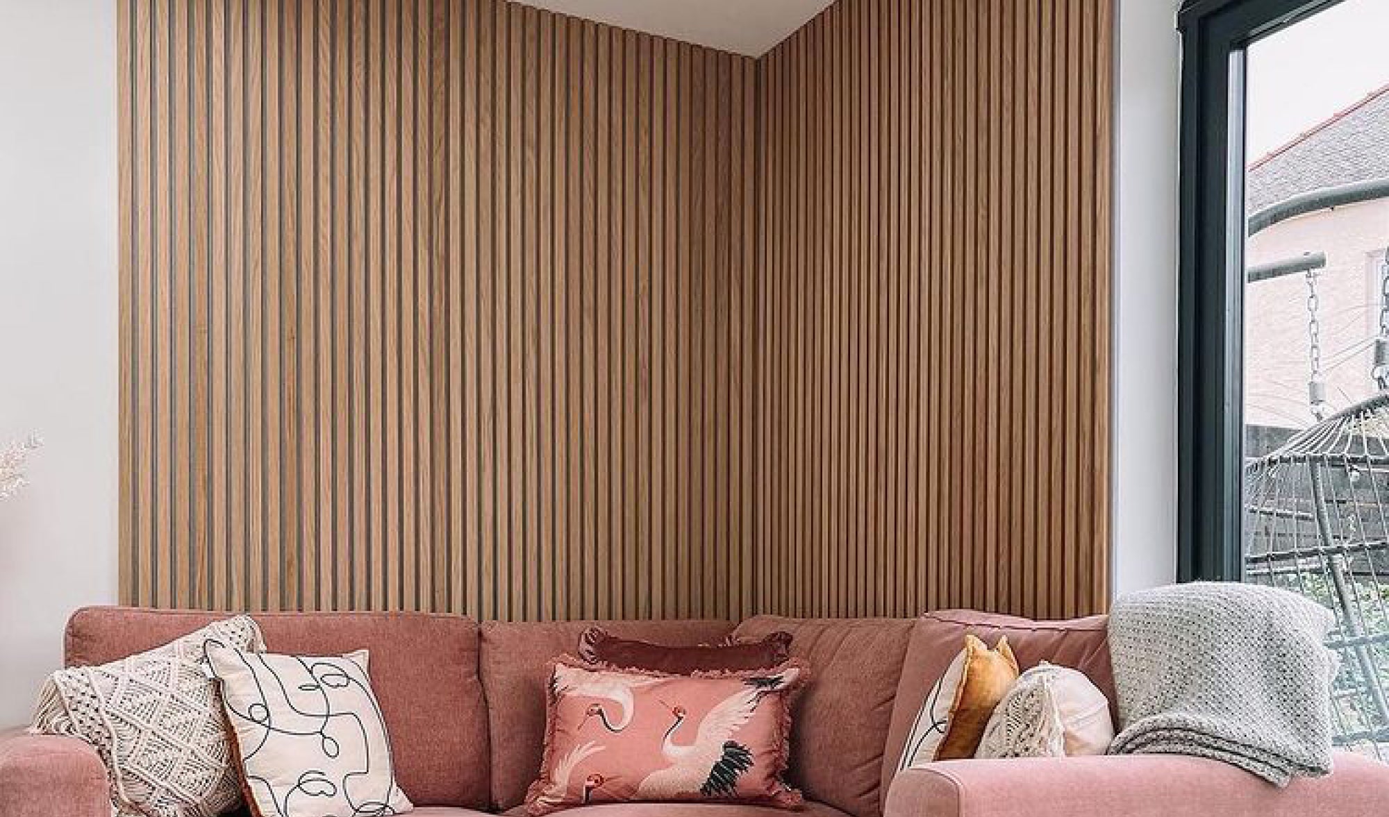 Salmon pink sofa in front of a Natural Oak on grey felt SlatWall wall