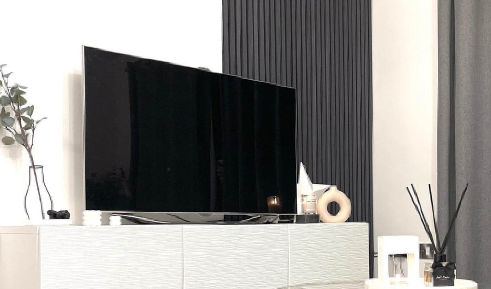 Single SlatWall panel on a bedroom wall behind a tv, on a white wall 