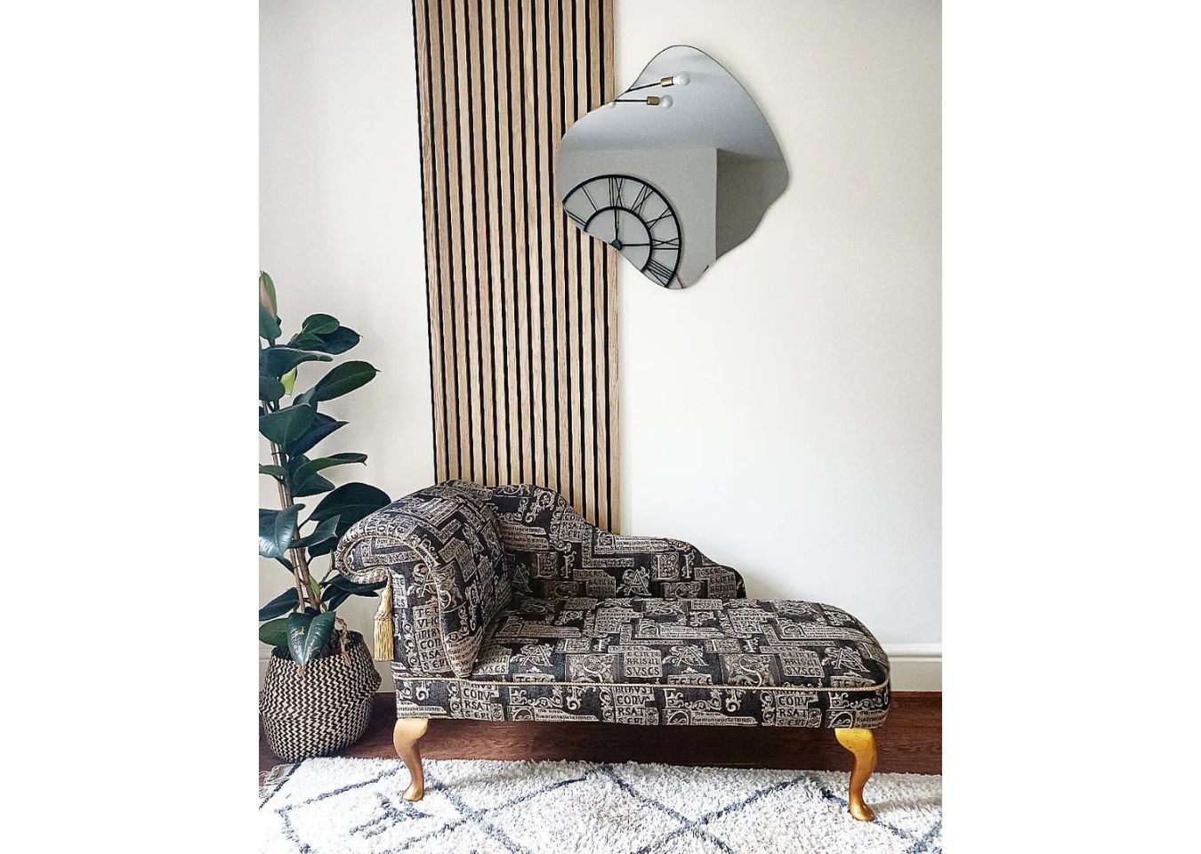 Chaise longue in front of single slatwall panel and house plant