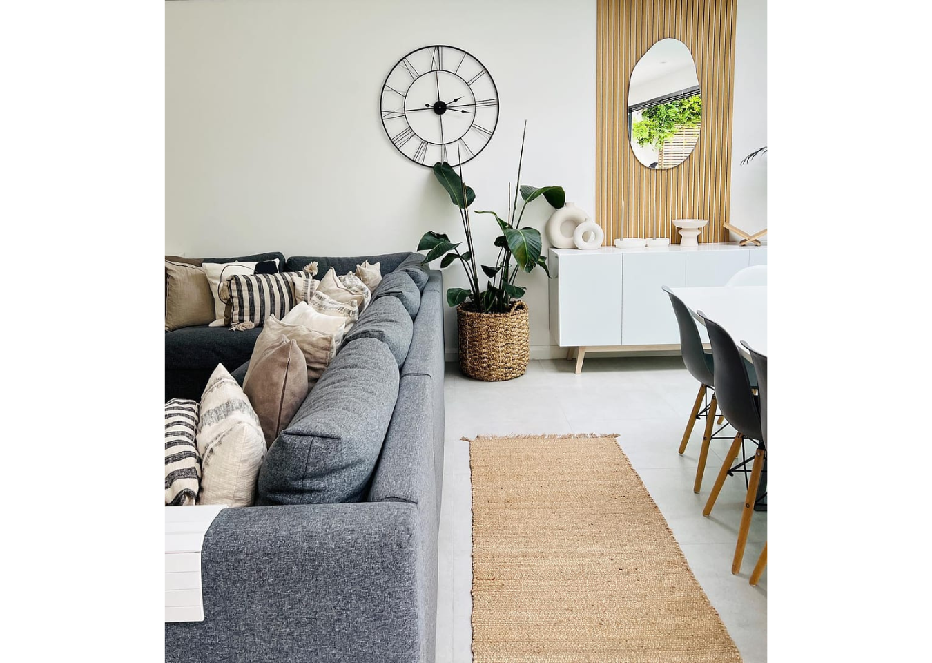 Single panel of SlatWall natural oak in Scandinavian interior design. Grey sofa to the left with jute rug behind.